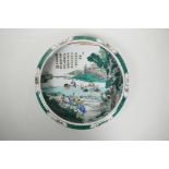 A Chinese famille verte porcelain dish with a rolled rim, decorated with figures in a rice paddy,