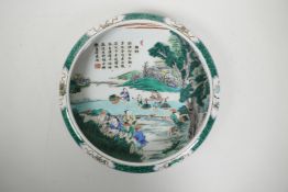 A Chinese famille verte porcelain dish with a rolled rim, decorated with figures in a rice paddy,