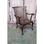 A mahogany Georgian style elbow chair with a cane back and seat, raised on cabriole supports with