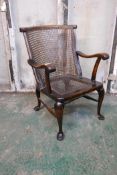 A mahogany Georgian style elbow chair with a cane back and seat, raised on cabriole supports with