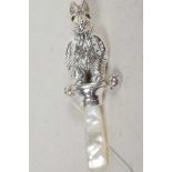 A silver baby's rattle in the form of Peter rabbit, with a mother of pearl handle, 3½" long
