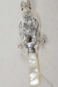 A silver baby's rattle in the form of Peter rabbit, with a mother of pearl handle, 3½" long
