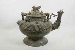 A Chinese bronze kettle with a dragon mask spout, dragon decoration to side and the cover