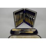 A cased pair of C19th ornate silver plated fish servers with twist ivory handles, together with a