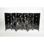 A Chinese black lacquer six fold table screen with abalone decoration depicting birds and insects