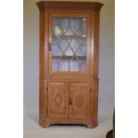 A large Irish pine two section corner cupboard with single astragal glazed door over two door