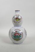 A Chinese double gourd porcelain vase with famille rose decorative panels depicting objects of