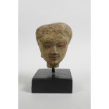 An Indian stucco bust of a woman, Gandharan style, 5½" high