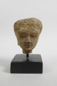 An Indian stucco bust of a woman, Gandharan style, 5½" high