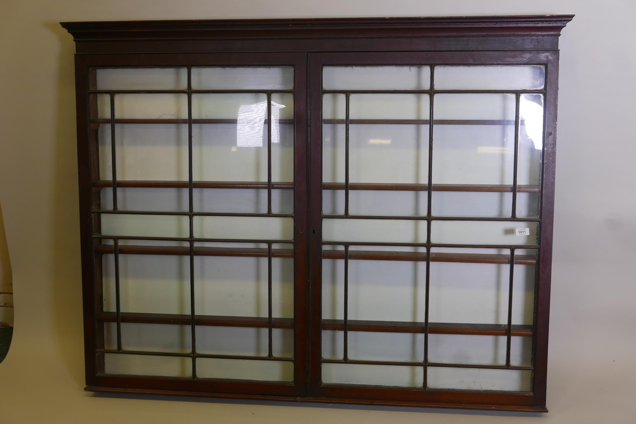 An early C19th hanging shop cabinet with two glazed doors, 60" x 6", 46½" high