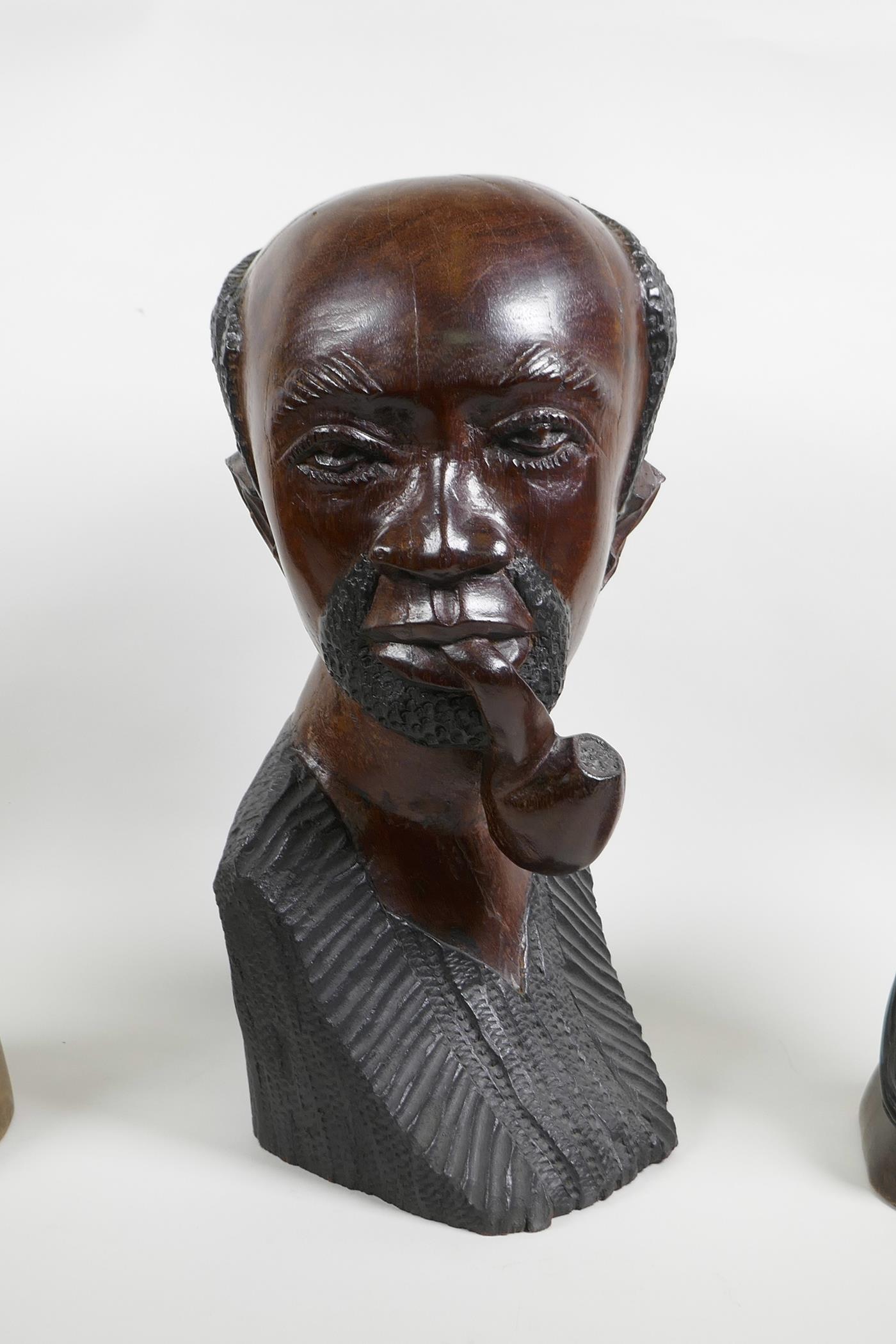 An African carved wood bust of a pipe smoking gentleman together with a pair of carved hardwood - Image 2 of 4