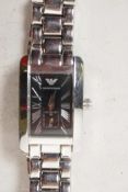 A lady's stainless steel cased dress wristwatch with black face and Roman numerals, on steel link