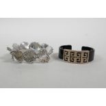 An acrylic bangle with rose metal Greek Key decoration, and a silvered metal bracelet with bobble