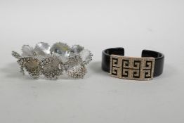 An acrylic bangle with rose metal Greek Key decoration, and a silvered metal bracelet with bobble