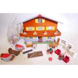 A mid C20th chalet style doll's house with a bag of furniture and utensils, 21" wide x 16" high x