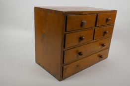 A small pine collector's chest of four short and two long drawers, 9½" high, 12½" wide, 7" deep