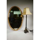 An oval Regency style gilt gesso mirror with reeded frame, crossed ribbon decoration and bevelled
