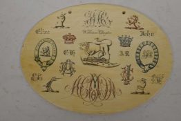 An oval Victorian ivory sample plaque engraved with elaborate initials and coats of arms, bears