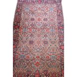 An antique hand woven wool and silk Sarook carpet, with traditional design on a red field, 78" x 50"