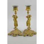 A pair of gilt metal figural candlesticks cast as male and female figures on garland triform
