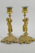 A pair of gilt metal figural candlesticks cast as male and female figures on garland triform