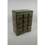 An Indian painted and distressed twelve drawer spice cabinet with brass banding, studs and