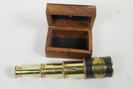 A three draw brass telescope in a fitted hardwood box, 7¼" long extended