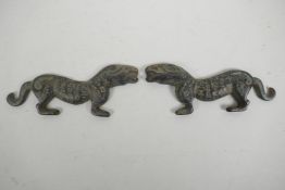 A pair of Chinese bronze scroll weights in the form of kylin with character inscriptions to side,