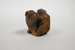 A late C19th/early C20th Japanese carved wood netsuke in the form of two Sharpei dogs, A/F, 1½" high