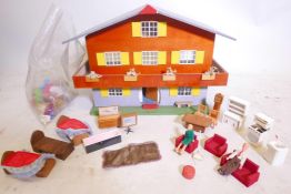 A mid C20th chalet style doll's house with a bag of furniture and utensils, 21" wide x 16" high x 14