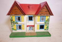 A mid C20th hand painted doll's house in plywood, with two opening doors at the front to reveal the