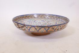 A glazed terracotta footed bowl with Islamic decoration, A/F, historic repairs to rim, 14" diameter