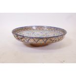 A glazed terracotta footed bowl with Islamic decoration, A/F, historic repairs to rim, 14" diameter