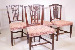 A set of four C18th mahogany Hepplewhite chairs, with carved and pierced reeded backs, decorated wit