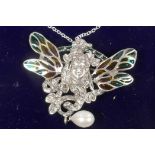 An Art Nouveau style silver pendant/brooch with face mask and plique a jour butterfly wings and pear