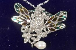 An Art Nouveau style silver pendant/brooch with face mask and plique a jour butterfly wings and pear