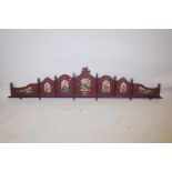 A Chinese carved and painted wood pelmet with decorative panels depicting pagodas, flowers, birds, i