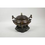 A Chinese two handled bronze censer on tripod supports with gilt splash decoration, a turned and car