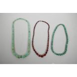 Two green hardstone graduated bead necklaces and another faceted and graduated bead necklace, 22" lo