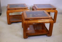 Three matching oriental style figured elm lamp tables, each with inset tinted glass, 25" x 25" x 22"