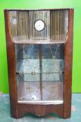 A mid C20th Hubbinet walnut corner display cabinet, with mirrored back and inset clock, and two slid
