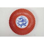 A Chinese blue and white porcelain petal shaped dish with a coral glazed exterior and dragon decora
