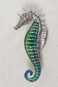 A silver and plique a jour brooch in the form of a seahorse with ruby eye, 2" long