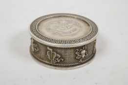 A Chinese white metal coin box and cover, the sides decorated with the emblems of the Eight Immortal