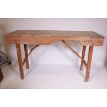 An antique pine workbench, with folding trestle supports, 60" x 20" x 34"