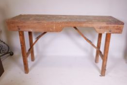 An antique pine workbench, with folding trestle supports, 60" x 20" x 34"