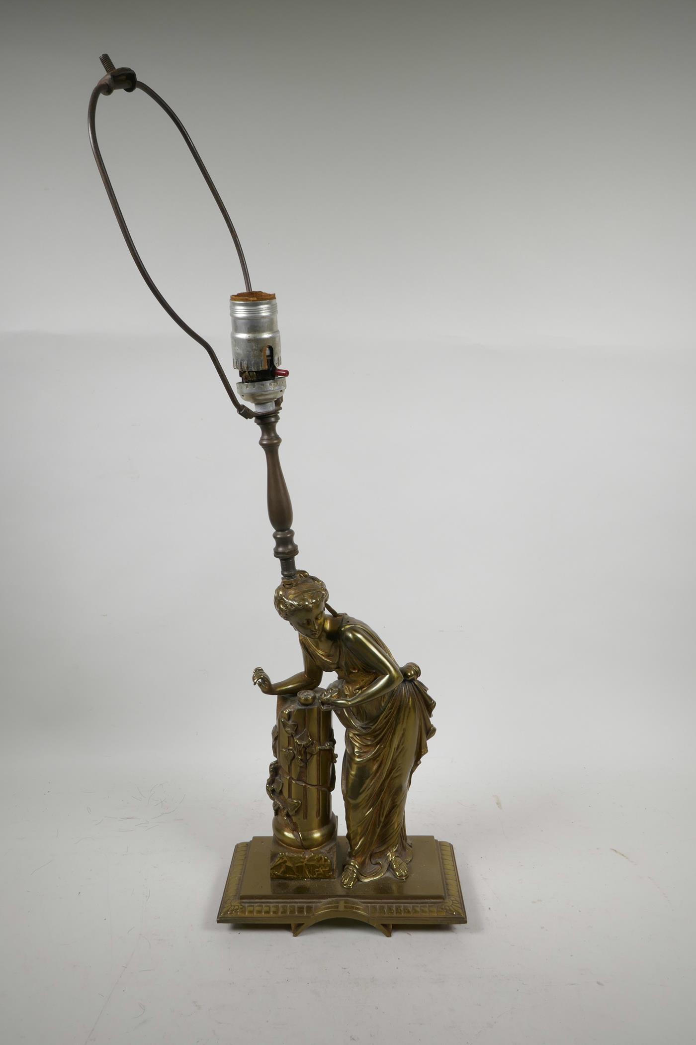 A brass table lamp in the form of a classical woman, 20" high