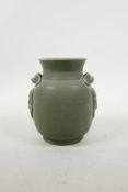 A Chinese Song style celadon glazed pottery pot with two lug handles and dragon mask decoration, 5½"
