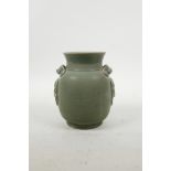 A Chinese Song style celadon glazed pottery pot with two lug handles and dragon mask decoration, 5½"