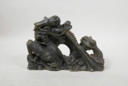 A Chinese carved green hardstone ornament in the form of a dragon, 9" long, losses